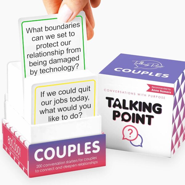 Close-up of hands holding Talking Point Couples Conversation Cards, creating a sense of intimacy.